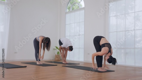 People Practicing Yoga Poses in Modern Yoga Studio