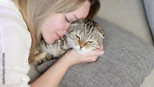 A woman kisses her cat.