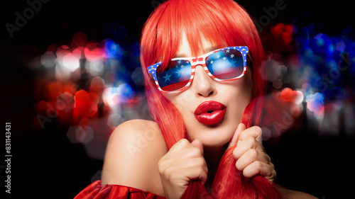 Canvas Print Sexy woman with red hair celebrates 4th July wearing American flag sunglasses an