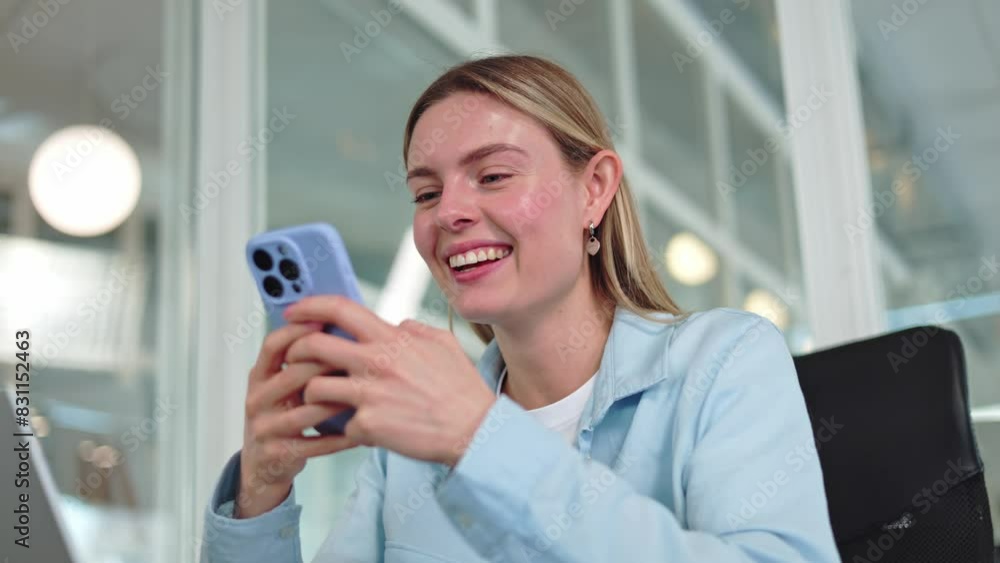Smiling caucasian woman typing on virtual keyboard of modern smartphone while having resting time in office interior. Enthusiastic female chatting with friends online indoors. Concept of achievement. Smiling caucasian woman typing on virtual keyboard of modern smartphone while having resting time in office interior. Enthusiastic female chatting with friends online indoors. Concept of achievement.