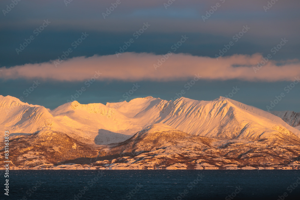 The magical light of the ending polar day on the snowy hills of Lofoten, Norway