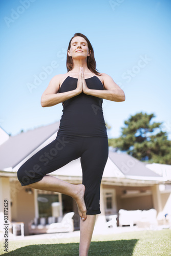 Woman, exercise or yoga outdoor in backyard for wellness, peace and health training in tree pose for balance. Female person, active and strong outside for pilates, relax or vrikshasana practice