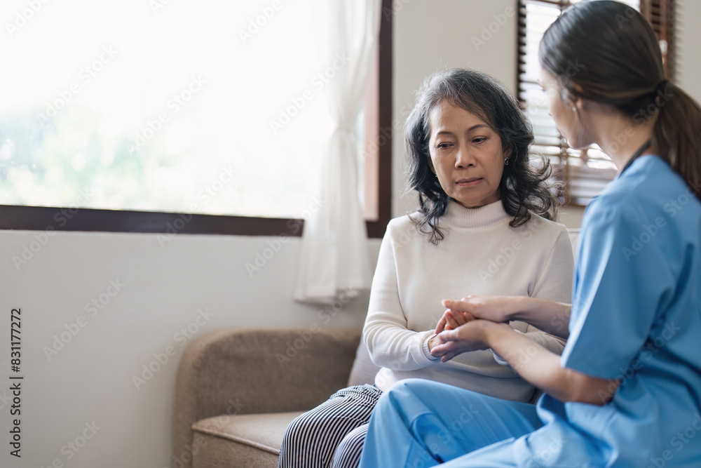 Nurse or caregiver comforting senior woman on sofa in home. Healthcare and emotional support concept Nurse or caregiver comforting senior woman on sofa in home. Healthcare and emotional support concept