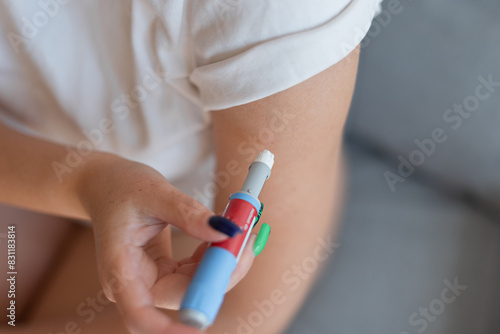 Girl gives herself an injection of anti diabetes in her arm at home. injectors dosing pen for subcutaneous injection of antidiabetic medication, anti-obesity medication. Weight loss