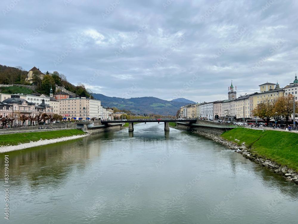 Marko-Feingold-Steg bridge above the Salzach River with the city shoreline in Salzburg, Austria, highlighting the bridge's modern design and scenic urban backdrop. Marko-Feingold-Steg bridge above the Salzach River with the city shoreline in Salzburg, Austria, highlighting the bridge's modern design and scenic urban backdrop.