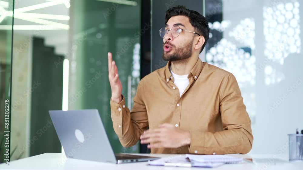 Angry excited manager arguing on video call using laptop computer sitting at workplace in business office. Dissatisfied boss emotionally talks with a subordinate about problems that need to be solved