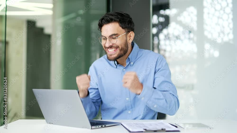 Happy excited businessman received great news on laptop while sitting at workplace in business office. Smiling worker reads a pleasant message on the computer, celebrates success, rejoices at the win Happy excited businessman received great news on laptop while sitting at workplace in business office. Smiling worker reads a pleasant message on the computer, celebrates success, rejoices at the win