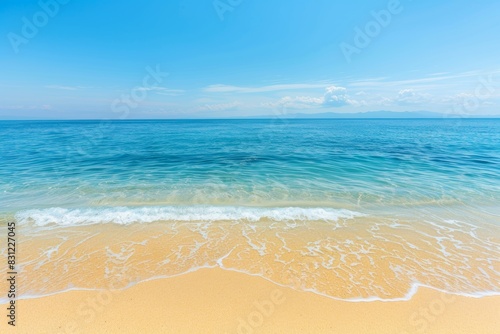 Serene beachscape with clear blue sky and gentle waves on sandy shore