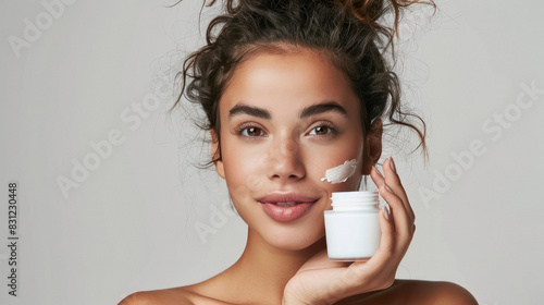 a young Indian woman holding a jar of cosmetic cream
