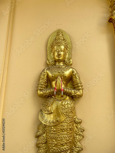 Golden Thai Buddhist Idol statue in Chiang Mai Thailand symbolizing worship at tourist temple.