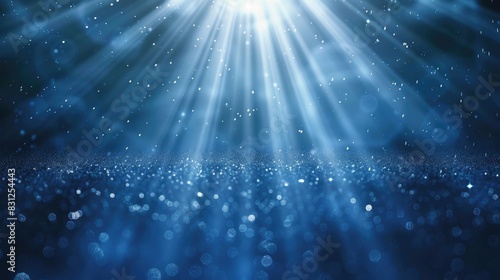 Continuous loop of enchanting blue glitter particles descending in soft, delicate light rays photo