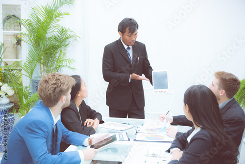 Corporate business team presentation with businessman using tablet in meeting room at modern office, manager or entrepreneur presentation about finance for planning marketing and brainstorming.