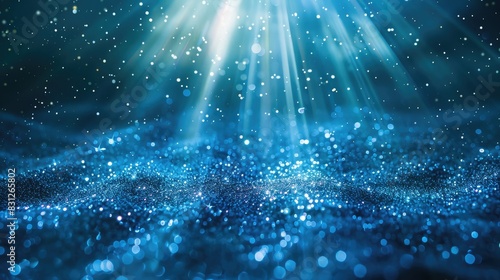 Blue glitter particles falling in a continuous loop, illuminated by delicate light rays for an enchanting effect
