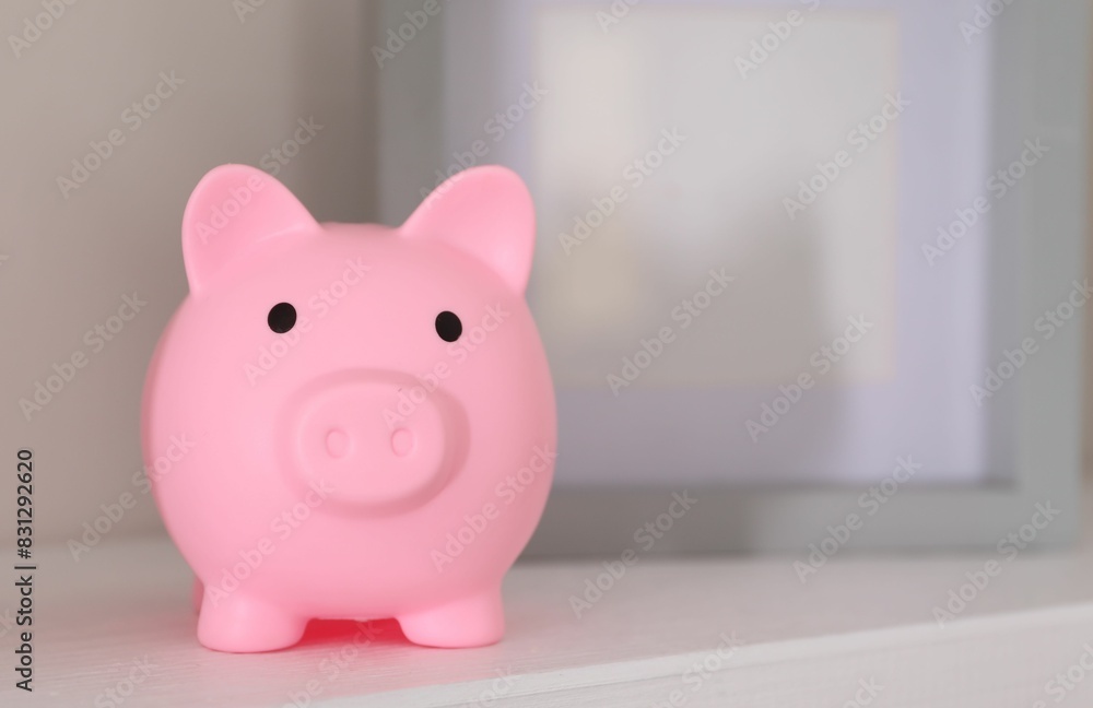 Pink piggy bank on white table, space for text Pink piggy bank on white table, space for text