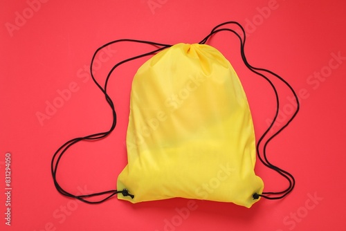 Yellow drawstring bag on red background, top view photo