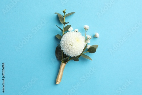 Small stylish boutonniere on light blue background, top view photo