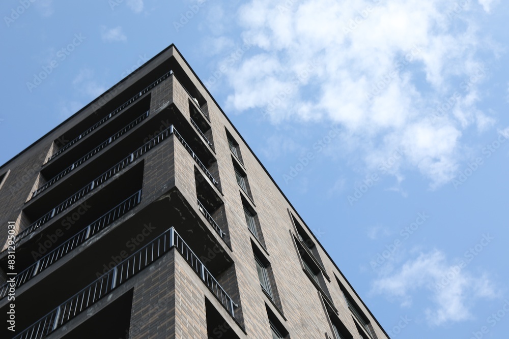 Modern building with big windows against blue sky outdoors, low angle view. Space for text Modern building with big windows against blue sky outdoors, low angle view. Space for text