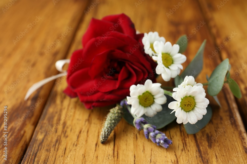 Small stylish boutonniere on wooden table, closeup Small stylish boutonniere on wooden table, closeup