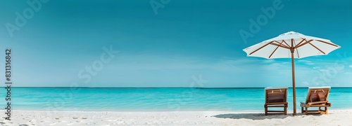 Panoramic view of white sandy beach with sunbeds under umbrella