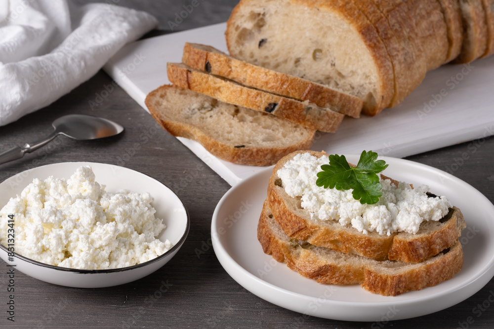 Home made bread on a wooden cutting board with curd cheese Home made bread on a wooden cutting board with curd cheese