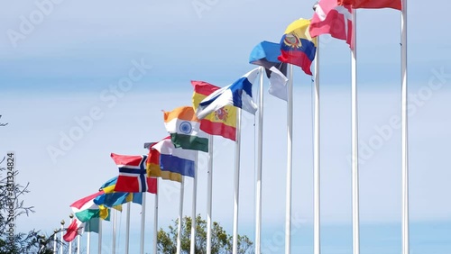 Row of Flagposts with National Flags Waving in the Wind during Official Meeting Conference or Sport Event