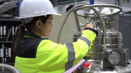 A Factory Engineer Checking Liquid Helium Levels in Storage Tanks, Ensuring Safety Compliance and Recording Usage for Machinery Operations in the Facility