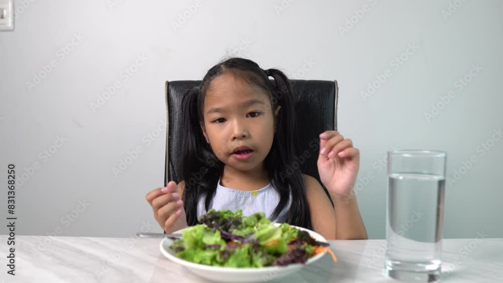An Asian Girl Refusing to Eat Vegetables at Dinner, Illustrating the Challenge of Encouraging Healthy Eating Habits in Children An Asian Girl Refusing to Eat Vegetables at Dinner, Illustrating the Challenge of Encouraging Healthy Eating Habits in Children