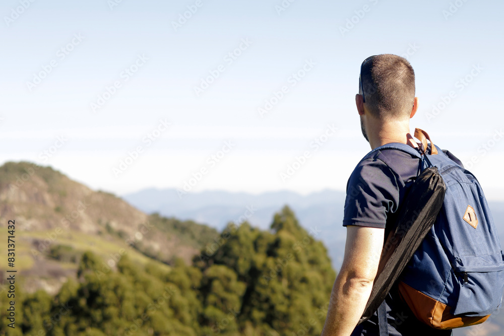 A man with a backpack looking at the mountains. A man with a backpack looking at the mountains.