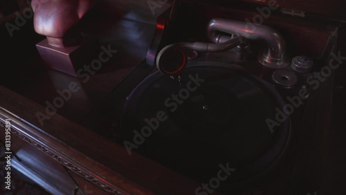 This video shows a close up view of an antique phonograph playing in moody lighting. 