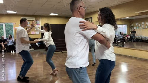 Smiling adults dancing salsa together in dance studio photo