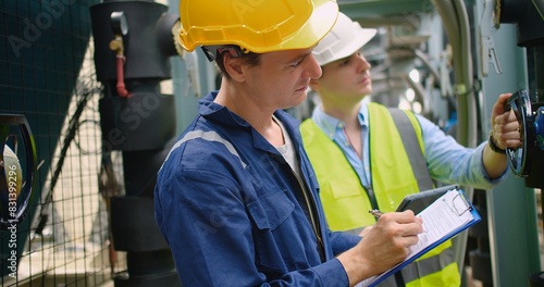 Civil engineer manager and foreman worker checking industry cooling air conditioner water cooling tower air chiller of large industrial building to control air system at construction site