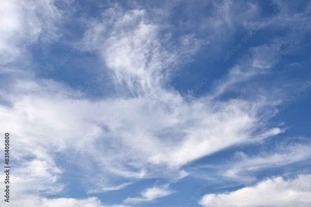 pure white fluffy clouds floating on clear blue sky, cloudscape background