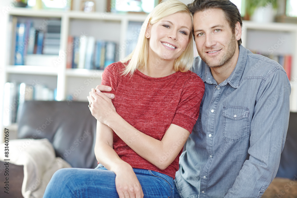 Couple, portrait and hug on sofa in home living room, bonding or relaxing and having fun. Smile, man and woman sitting on couch for embrace or love, happiness and security together for support