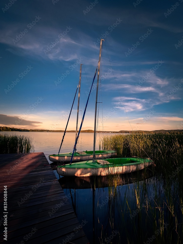 Żaglówki na tle zachodzącego słońca. Warmia Mazury