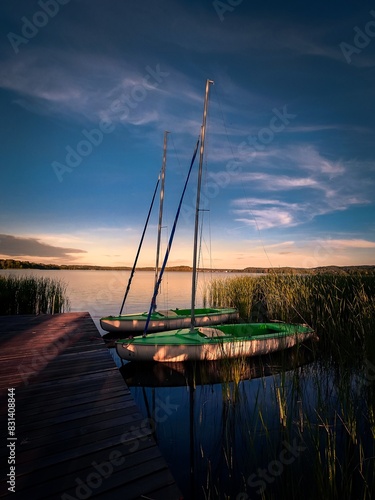 Obraz na płótnie Żaglówki na tle zachodzącego słońca. Warmia Mazury w salonie