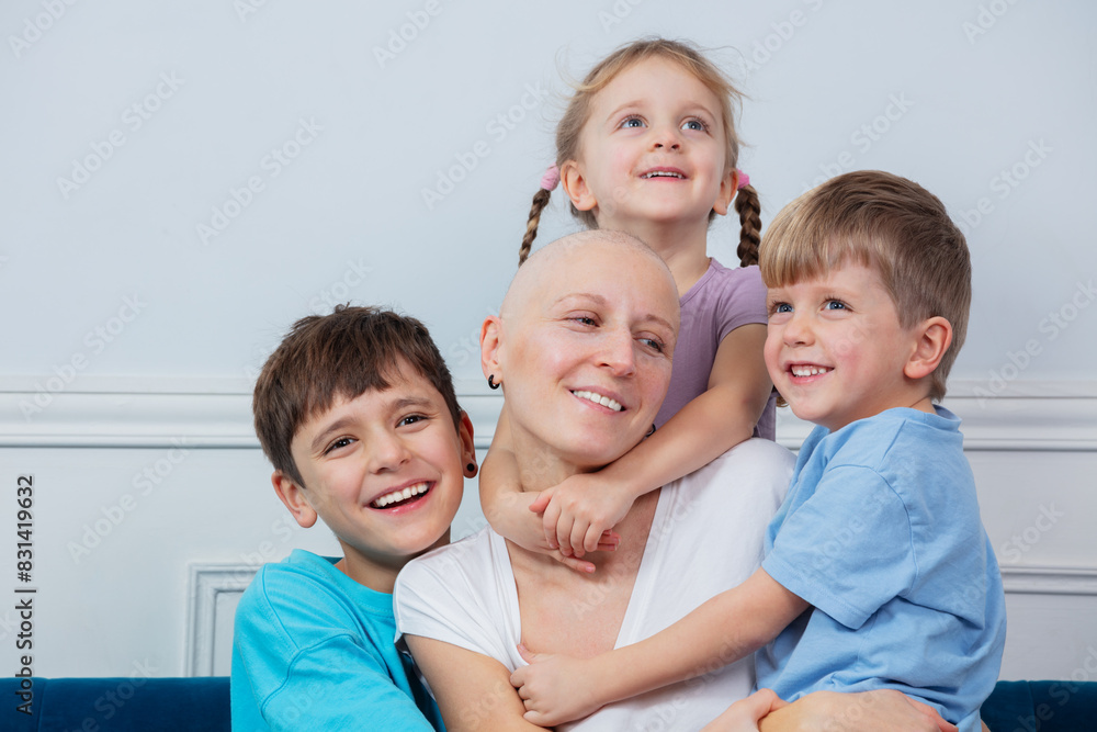 A smiling bald mother enjoys warm supporting hug from her kids A smiling bald mother enjoys warm supporting hug from her kids