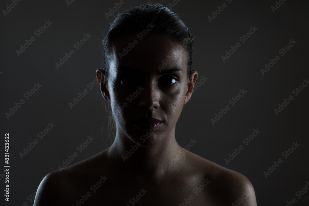 Dramatic portrait of a young woman with shadow and light play Dramatic portrait of a young woman with shadow and light play