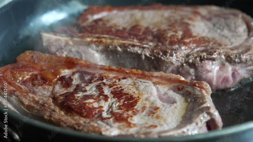 Partially cooked steaks in a pan, starting to brown, close-up view, home cooking, delicious meal in progress, fresh beef, culinary preparation, sizzling sound, detailed kitchen scene Partially cooked steaks in a pan, starting to brown, close-up view, home cooking, delicious meal in progress, fresh beef, culinary preparation, sizzling sound, detailed kitchen scene