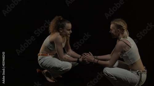 Two Women Practicing Capoeira in Low Light photo