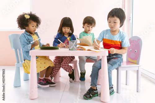 Group of Multi-ethnic children drawing with colored pencil in art classroom at kindergarten. Group of children pupils doing fun activity together at International School. Back to school concept.