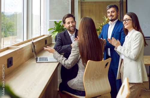 Group of a happy business people standing in office near the workplace and making successful deal or signing contract or greeting new employee. Coworkers talking with colleagues and applauding.