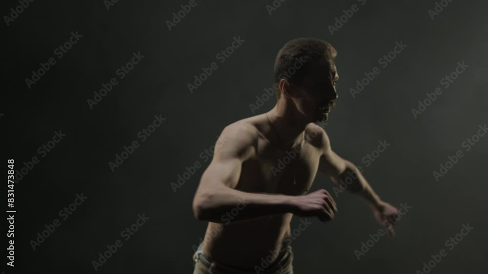 Group of a professional dancers are practicing capoeira in darkness against a spotlight on a black background of studio. Afro-Brazilian martial art that combine elements of dance. Group of a professional dancers are practicing capoeira in darkness against a spotlight on a black background of studio. Afro-Brazilian martial art that combine elements of dance.