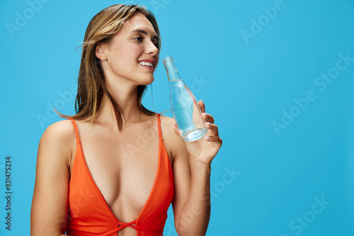 Fotografie Refresh and recharge a vibrant woman in orange swimsuit enjoying a hydrating mom