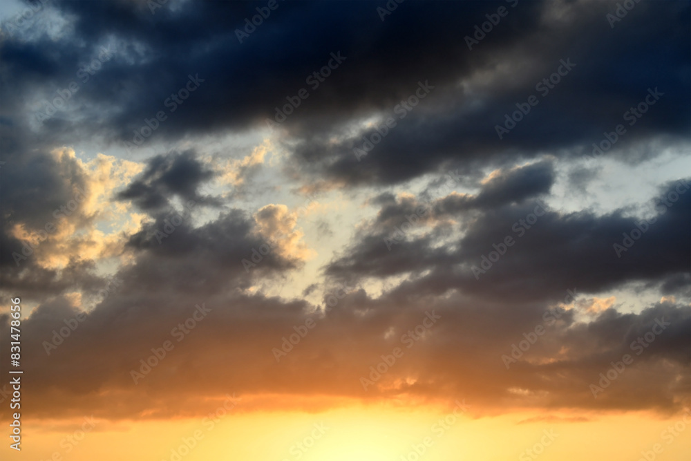 Dramatic dark fluffy clouds with sunset sky. Beautiful summer nature in the evening. Cloudscape background. 