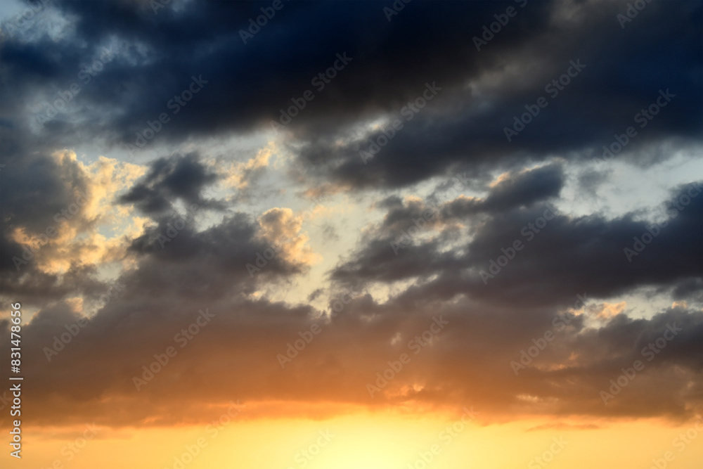 Dramatic dark fluffy clouds with sunset sky. Beautiful summer nature in the evening. Cloudscape background. Dramatic dark fluffy clouds with sunset sky. Beautiful summer nature in the evening. Cloudscape background.