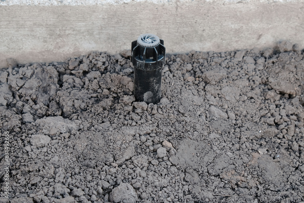 Fototapeta premium Sprinkler for automatic watering on a flexible connection close-up, the process of installing a pipeline from HDPE pipes