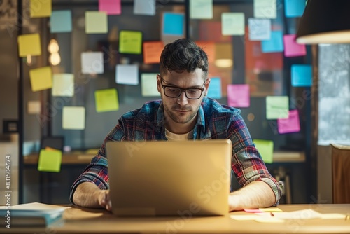 Intense Concentration as Young Male Entrepreneur Engages in Late Night Work Session Surrounded by Ideas photo