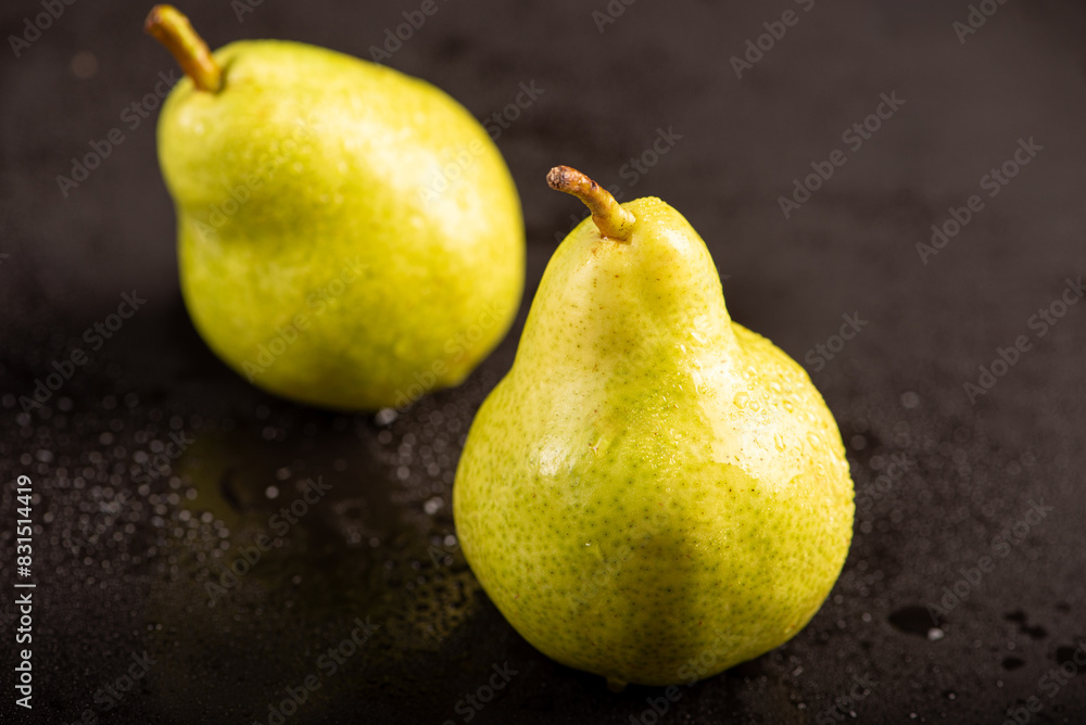 Beautiful pears placed on dark reflective surface, selective focus.