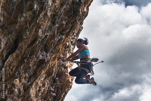 A woman climber falls into the void while climbing a very difficult wall.