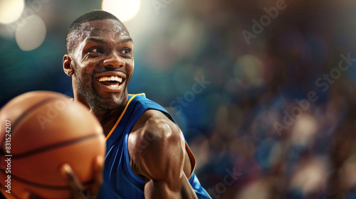 A muscular man in a blue jersey holding a basketball and smiling on a brightly lit indoor court © Irina B